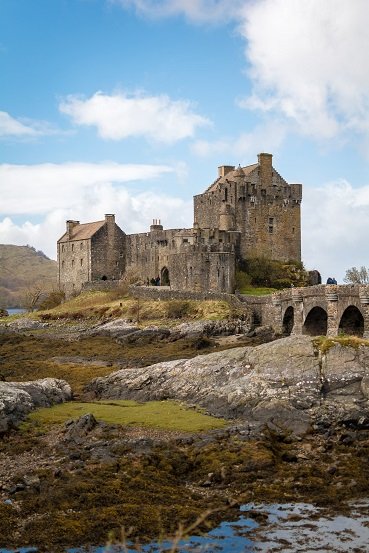 A castle perched on a rocky hill, surrounded by natural terrain.